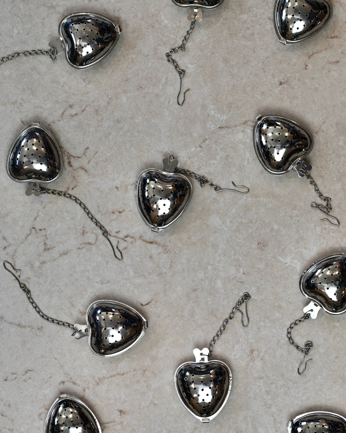 FreeWildShe Strawberry Infusers lay scattered on a cream colored countertop.