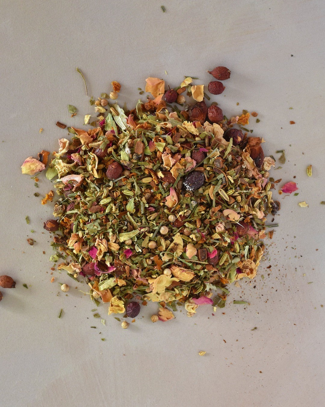 FreeWildShe NW Chai Herbal Tea loose leaf ingredients lay in a pile on a cream countertop.