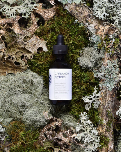 FreeWildShe Cardamom Bitters sit on moss & lichen.