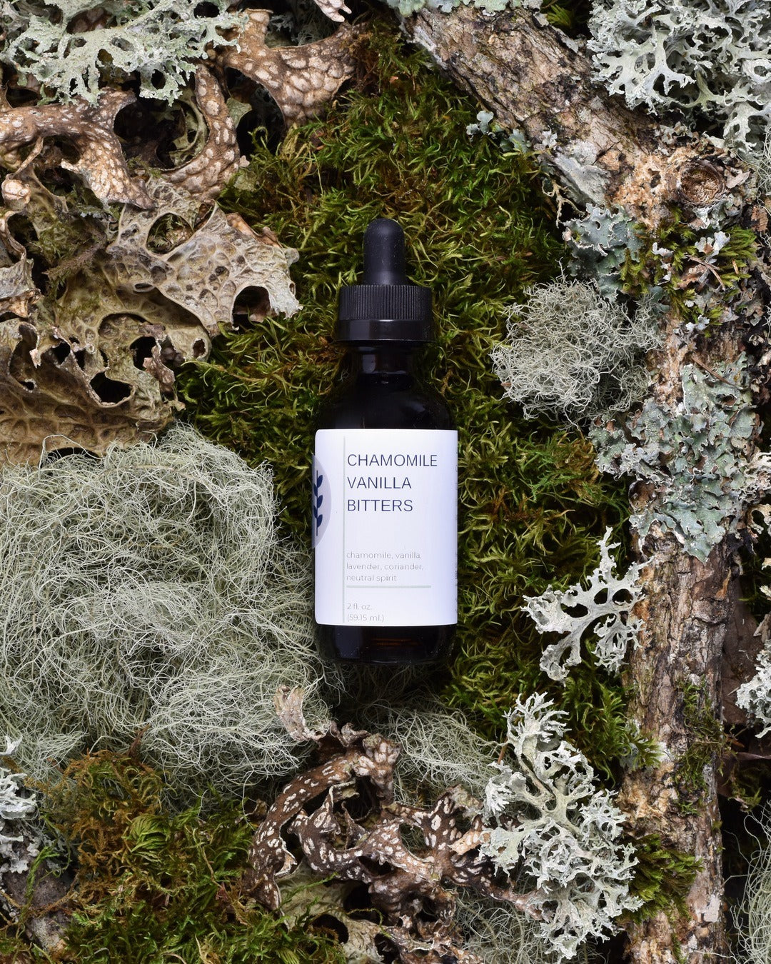 FreeWildShe Chamomile Vanilla Bitters sit on moss & lichen.