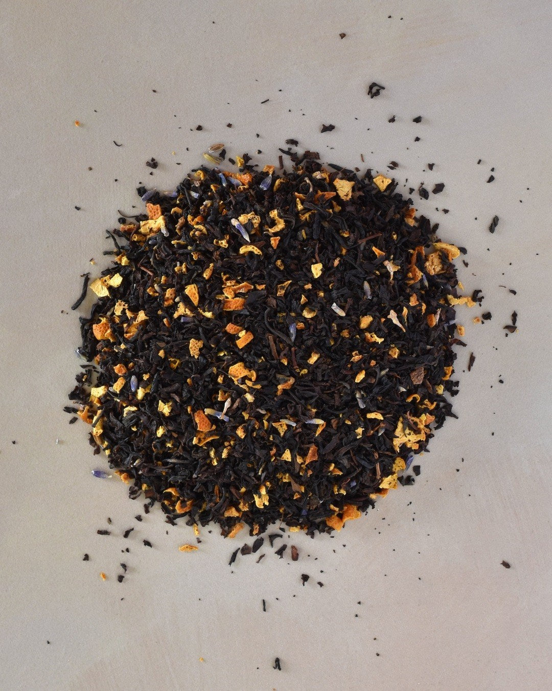 FreeWildShe Grey Lady Black Tea loose leaf ingredients lay in a pile on a cream countertop.