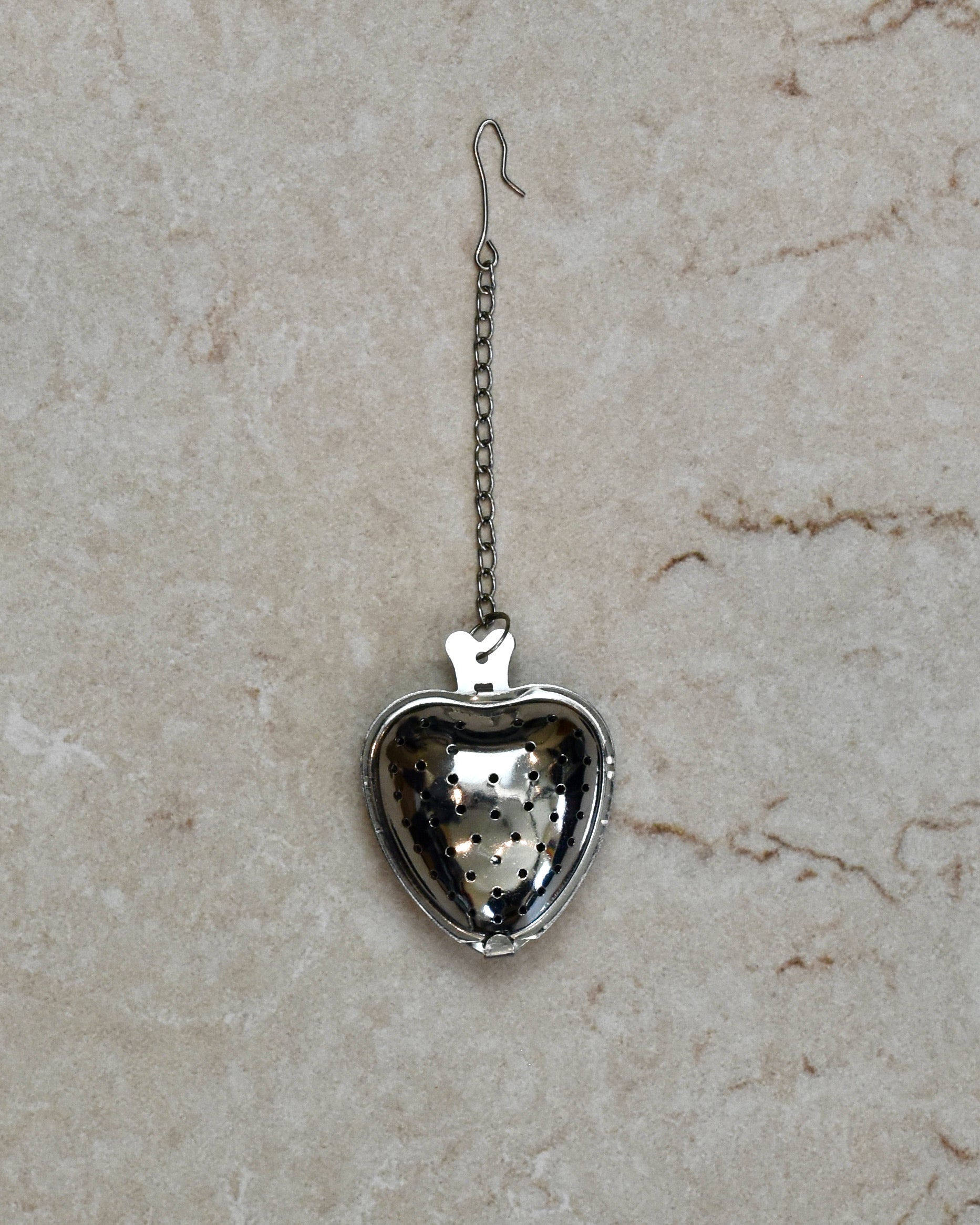 A FreeWIldShe Strawberry Infuser lays in the center of a cream colored countertop.