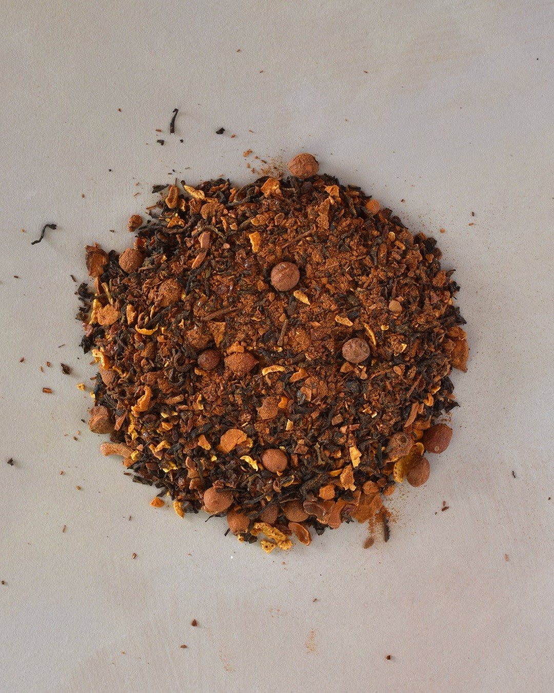 FreeWildShe Heartwarming Black Tea loose leaf ingredients lay in a pile on a cream countertop.