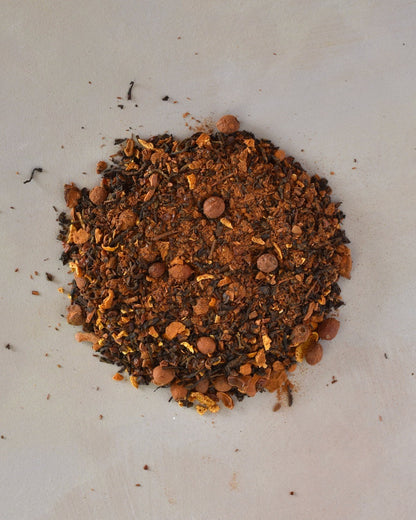 FreeWildShe Heartwarming Black Tea loose leaf ingredients lay in a pile on a cream countertop.