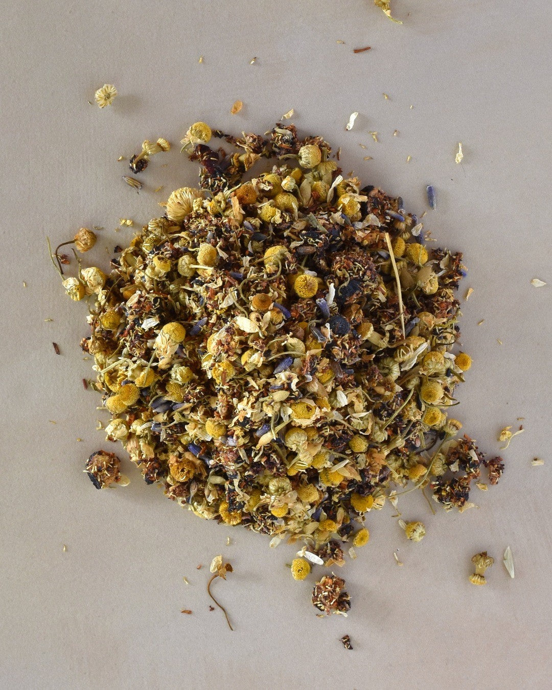 FreeWildShe Hygge Herbal Tea loose leaf ingredients lay in a pile on a cream countertop.