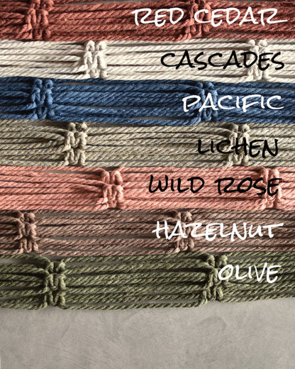 FreeWildShe Ayla Macrame Plant Hanger colors all lined up next to one another. The color labels read: red cedar, cascades, pacific, lichen, wild rose, hazelnut, olive.