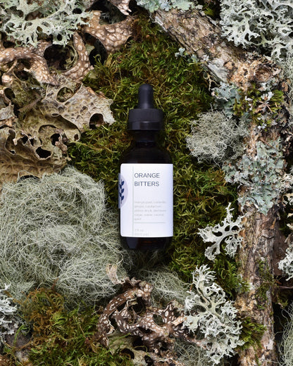 FreeWildShe Grapefruit Bitters sit on moss & lichen.